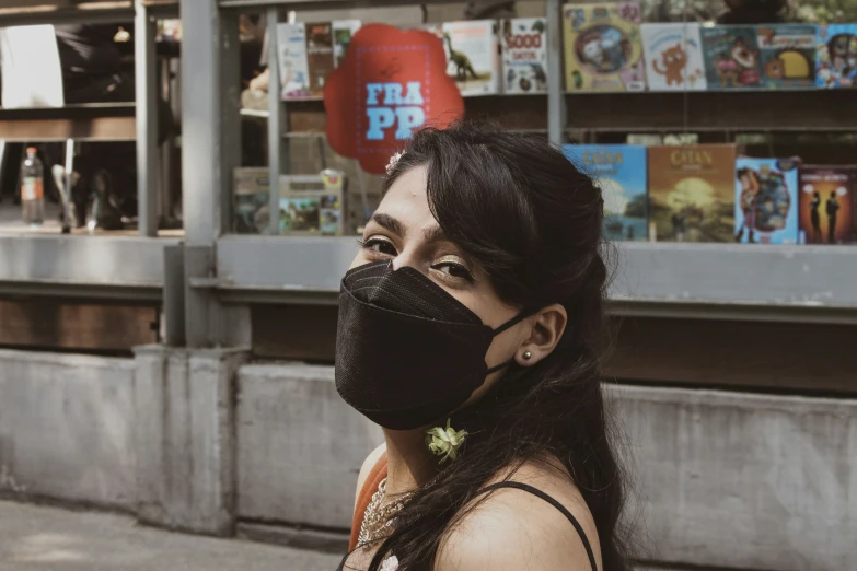 a woman is wearing a mask in front of a bookshelf