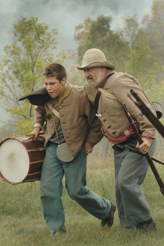 two men walking with gun, drums and muskes