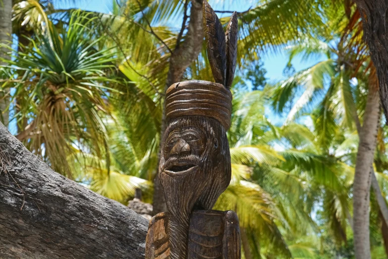 an odd looking carved wooden object in front of some trees