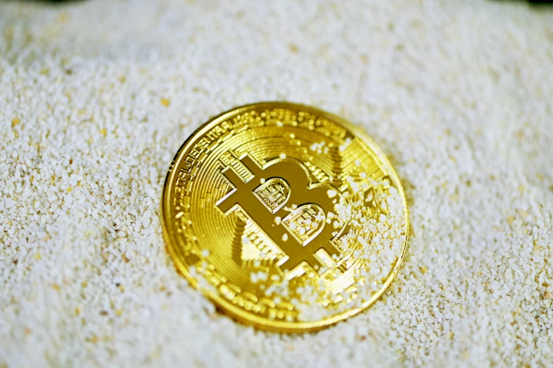 closeup of golden bit coin in snow