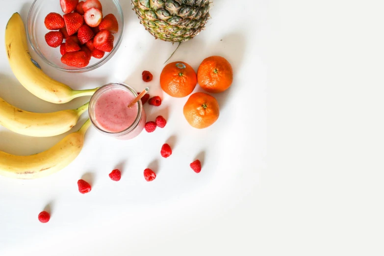 fruits in bowls next to strawberries and bananas