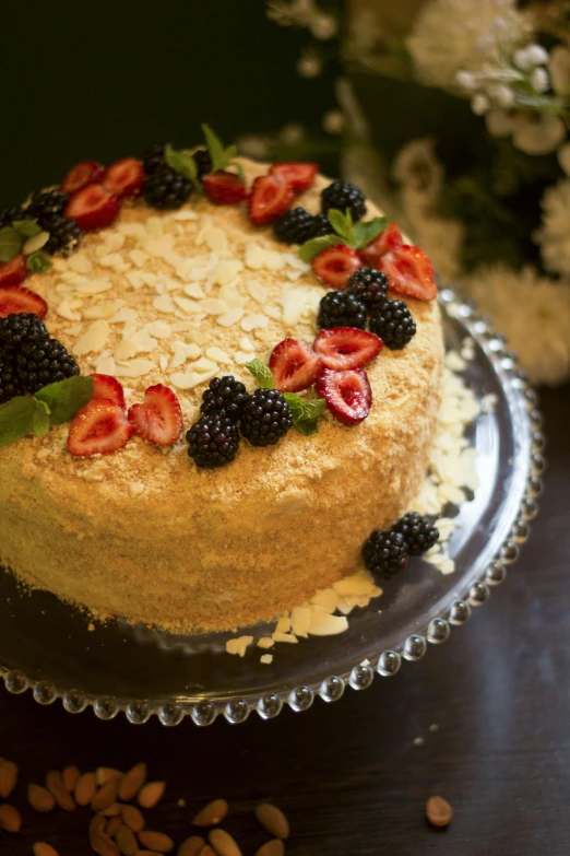 the cake is decorated with berries and green leaves