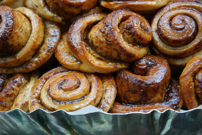 cinnamon buns are on a green and silver dish