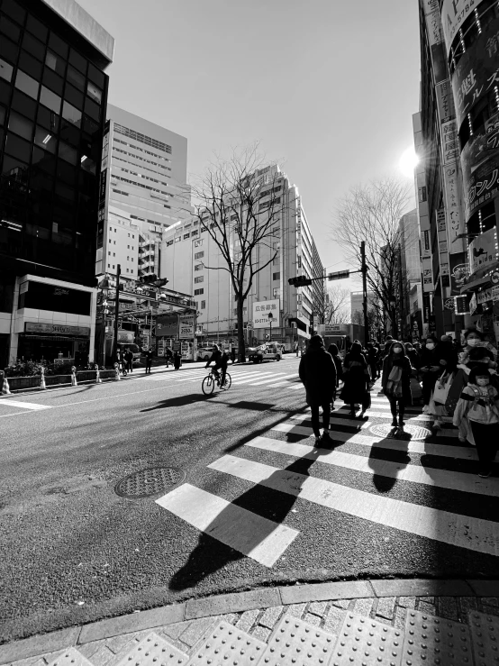 people riding horses on a city street with tall buildings