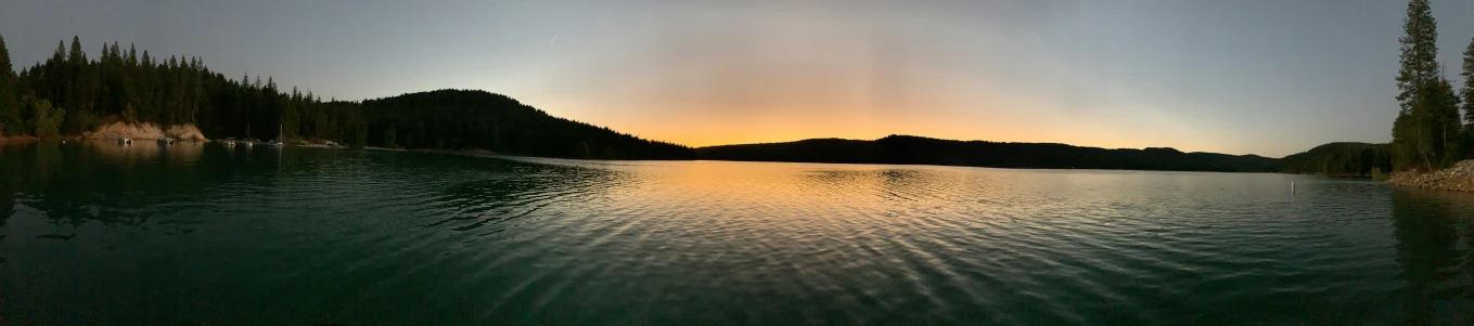 the sun is shining brightly over the calm lake