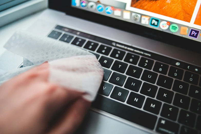 the hand is putting a paper over the keyboard of a laptop