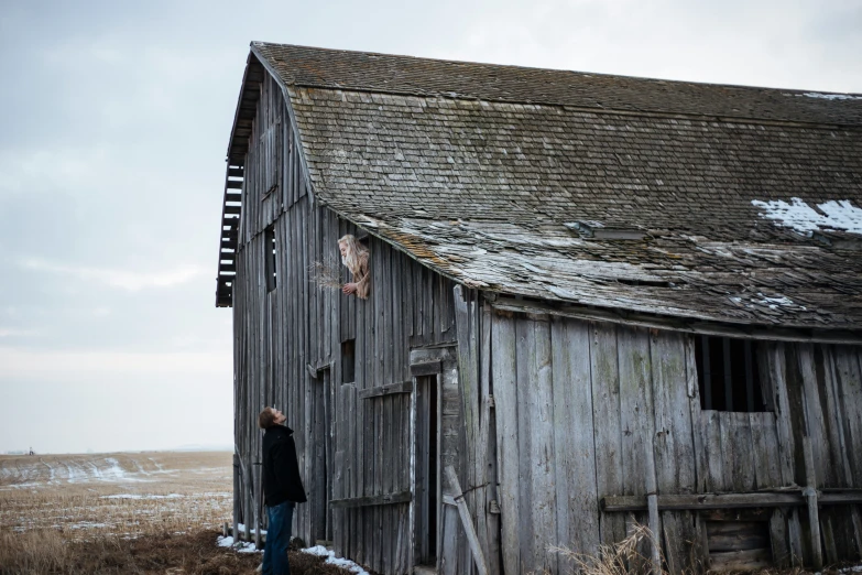 a man is standing in front of an old shed