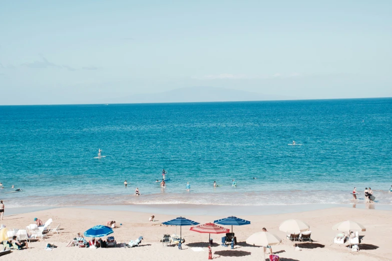 beach scene with people and chairs in the water