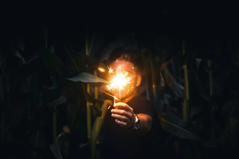 a person holding a sparkler in the dark