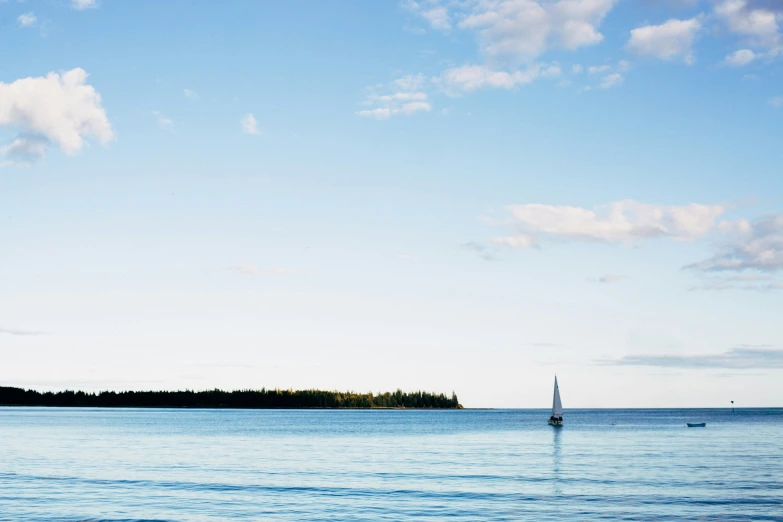 an island with trees and people in it sits on the ocean