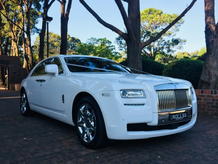 a white car parked on top of a brick road