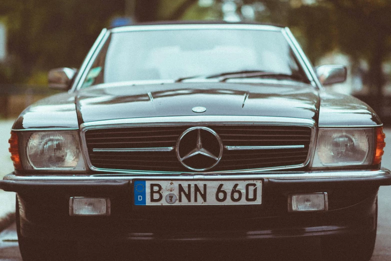 a black mercedes benz sits in front of a parked car