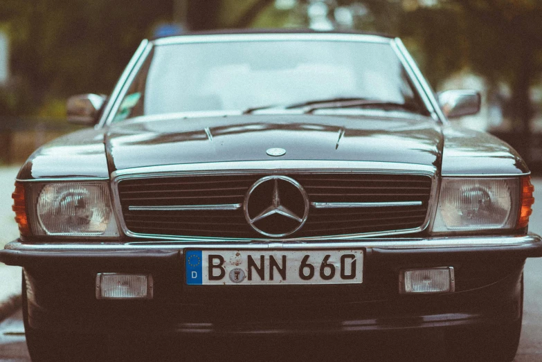 a black mercedes benz sits in front of a parked car