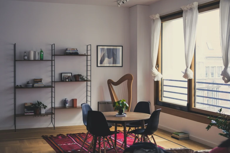 this room has a small dining table and shelves that have books on them