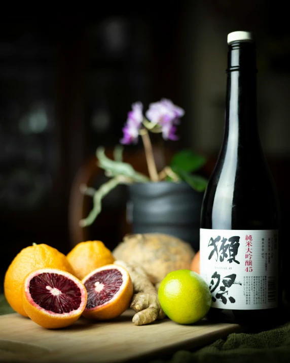 an assortment of fruit sitting on the counter next to a bottle