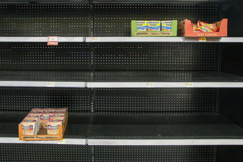 an empty grocery aisle with two boxes of candy and a box of cereal on the shelf