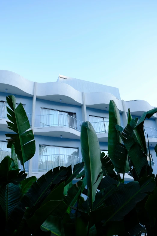 an odd building with plants and a sky background