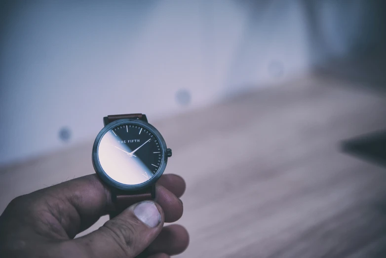 man holding a watch while taking off it with his hand