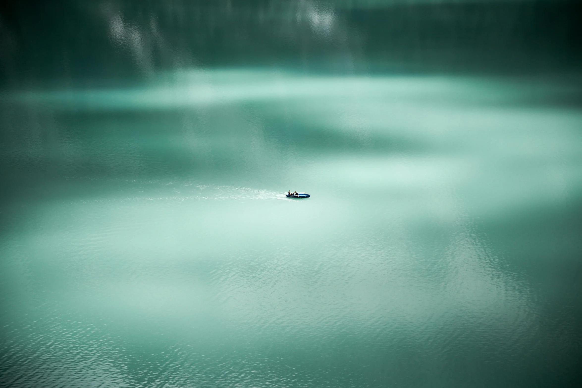 a couple of small boats floating on top of a lake