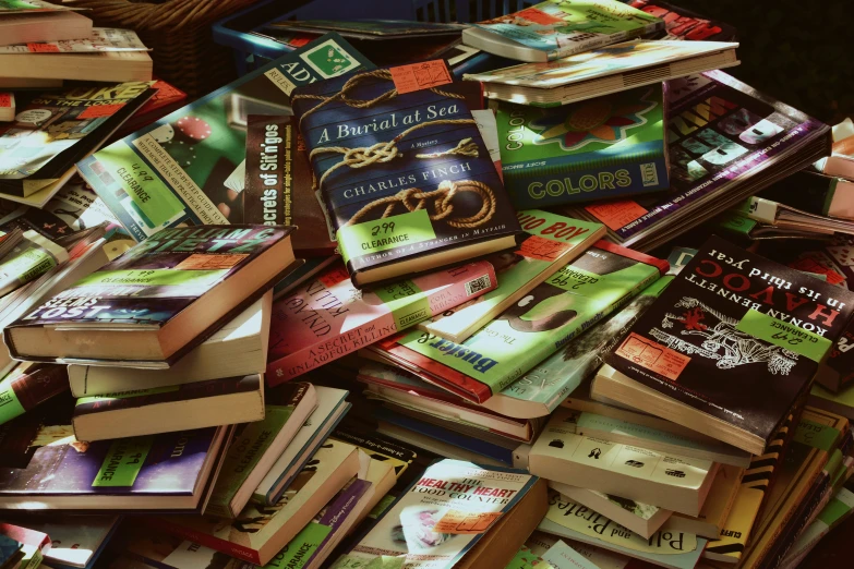 a pile of books with an open lid and a stuffed animal in front