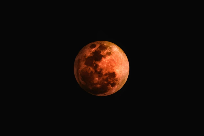 a full orange moon in the sky at night