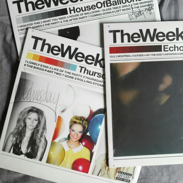 three magazines on grey sheet, one reads the week echo and two is of women's faces