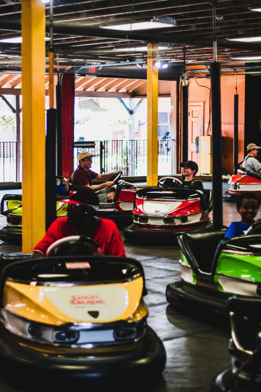 several small children sitting in bumper cars at a theme park