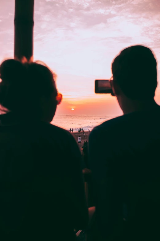 people standing on an observation deck watching the sunset