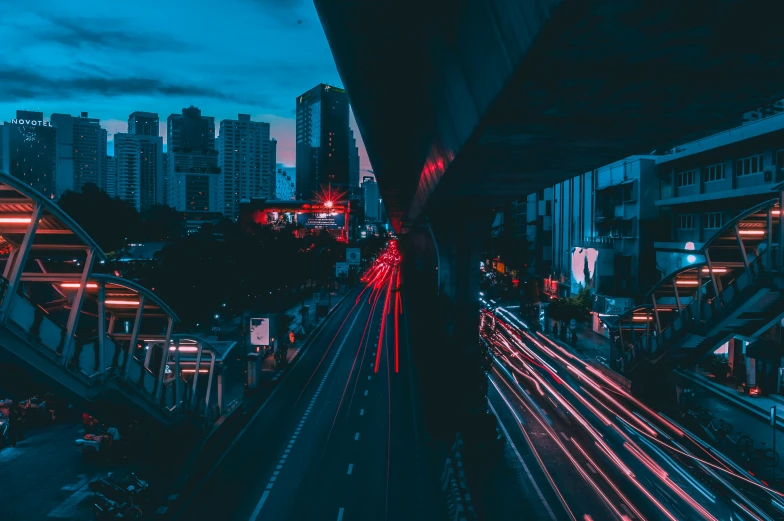 city street at night with traffic lights, skyscrs and elevated walkway