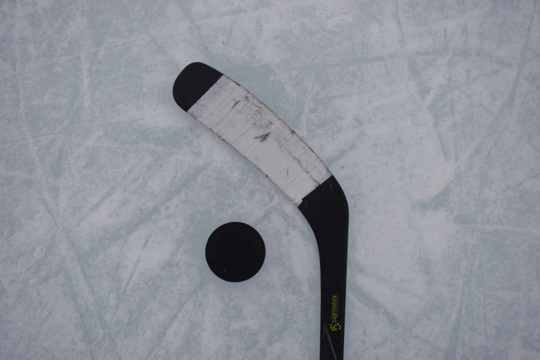 a hockey stick sitting next to a ball on the ground