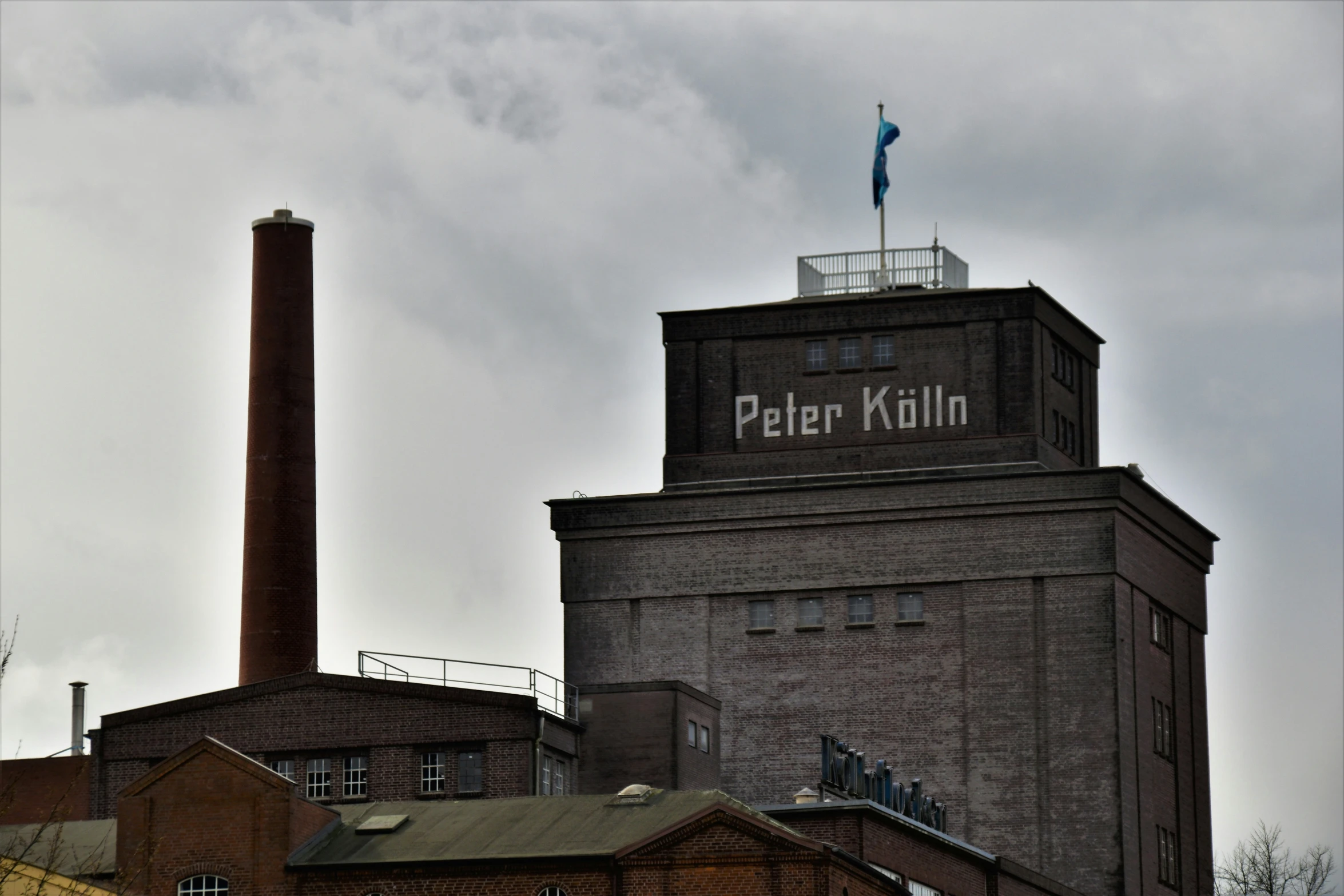 a tall building with a blue flag and an antenna