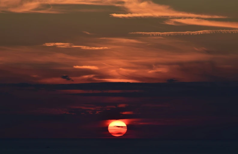 a sky at sunset with the sun in the distance