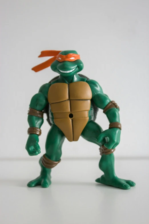 a toy turtle holding a wooden stick in his hands