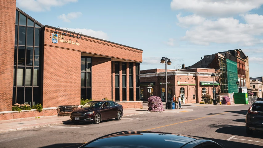 a street with two cars parked near large buildings