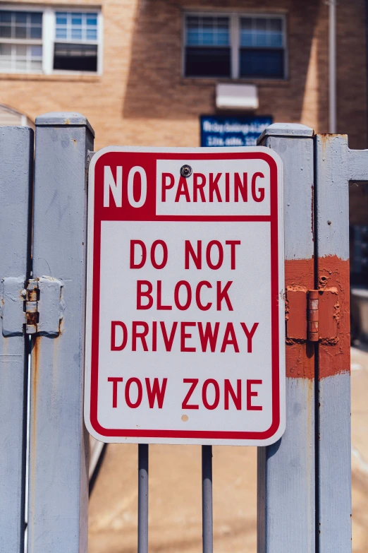 a no parking sign is posted on a gate