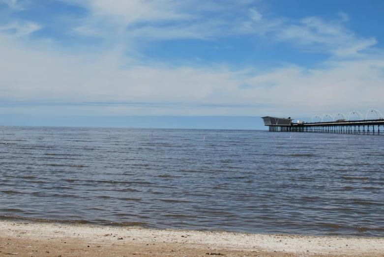 a large pier sitting on top of a beach near the ocean