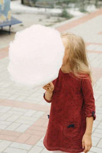 the little girl is playing with a large white ball