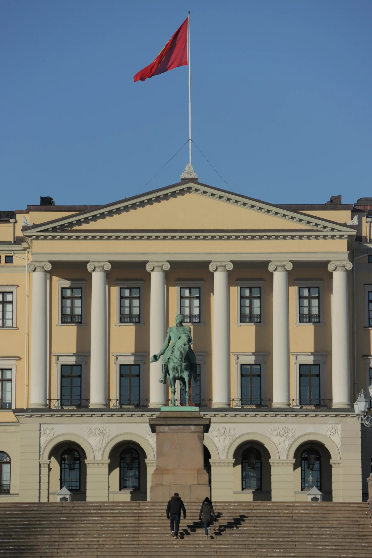 there is a building with columns and a statue on top