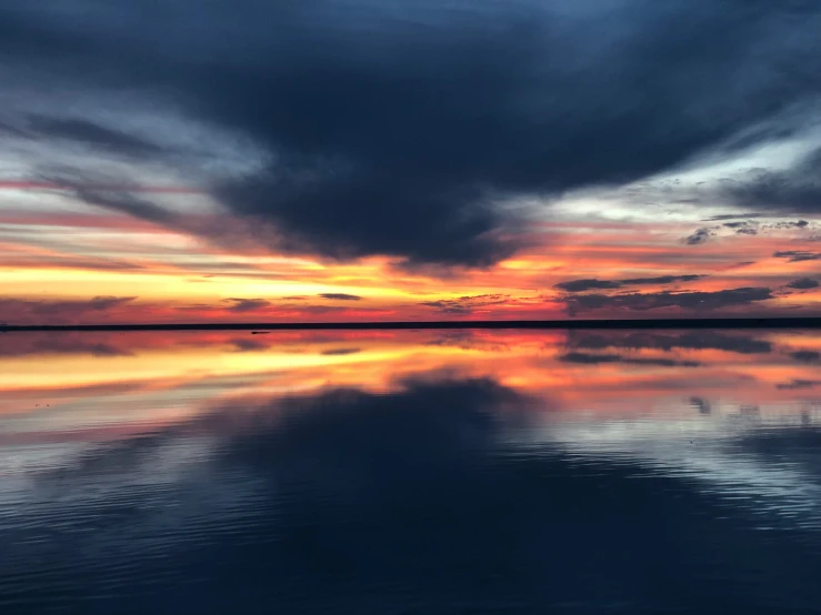 colorful sky reflecting on calm water in evening