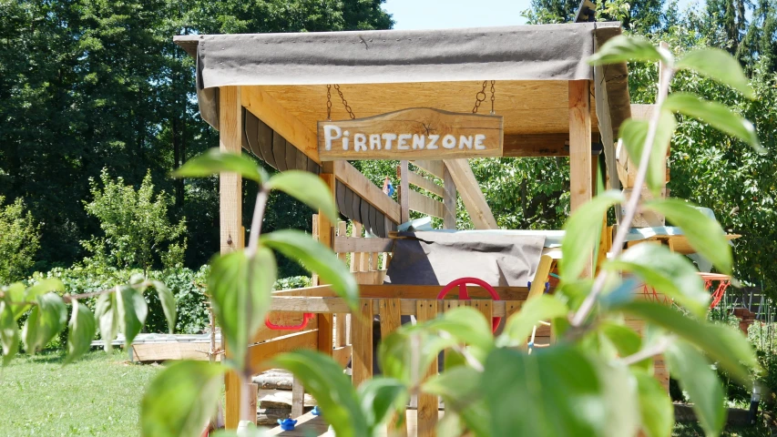 a garden with lots of wooden furniture next to green grass