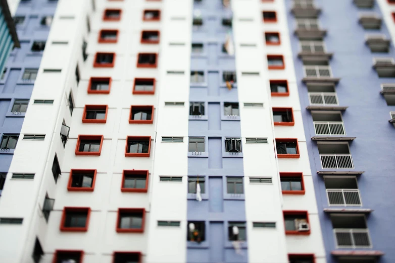 a multi - colored building has several windows with red and white frames