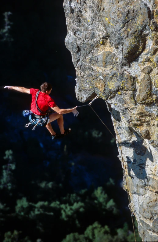 a man bundesurging from a cliff high above the tree line