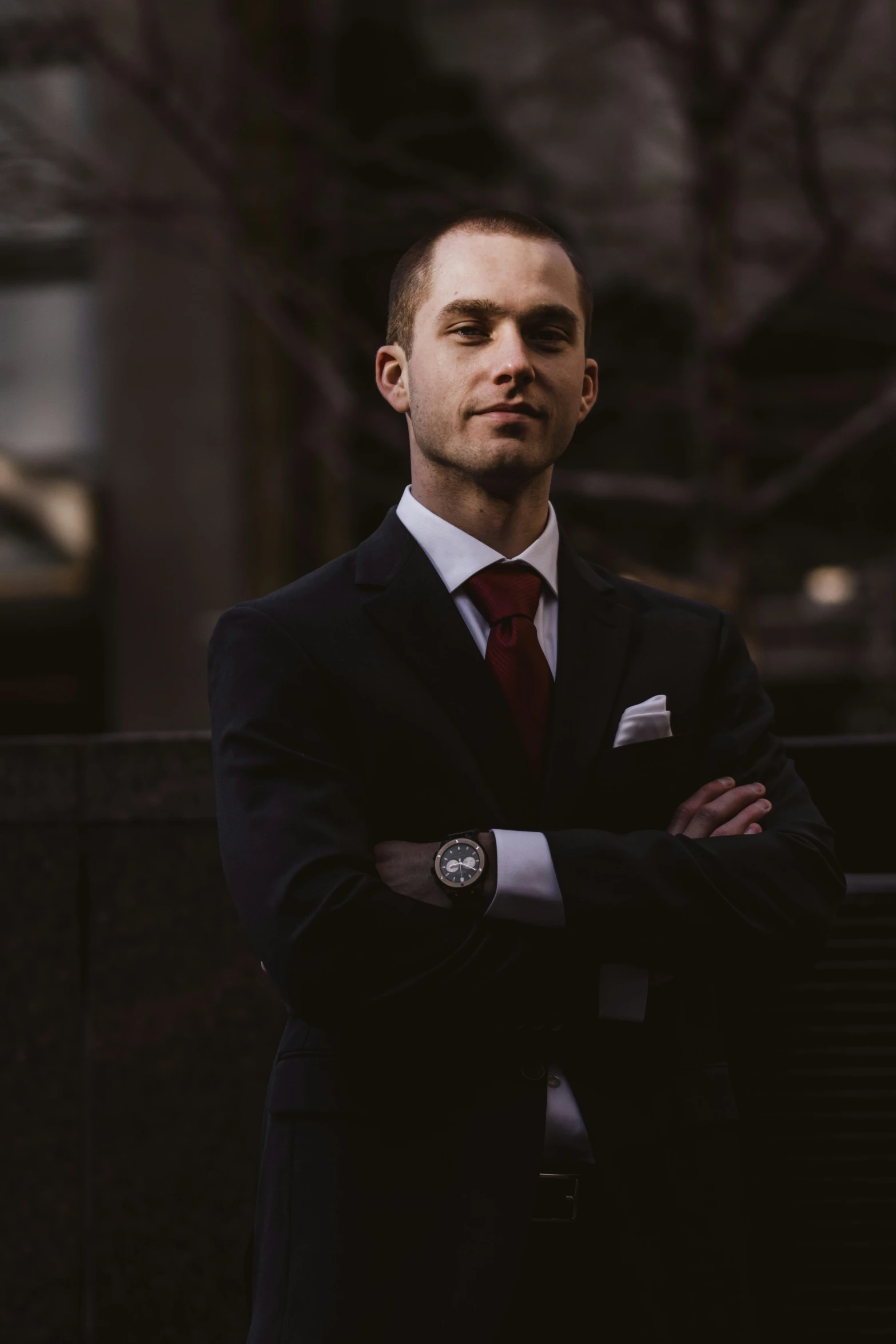 a man wearing a black suit and tie posing