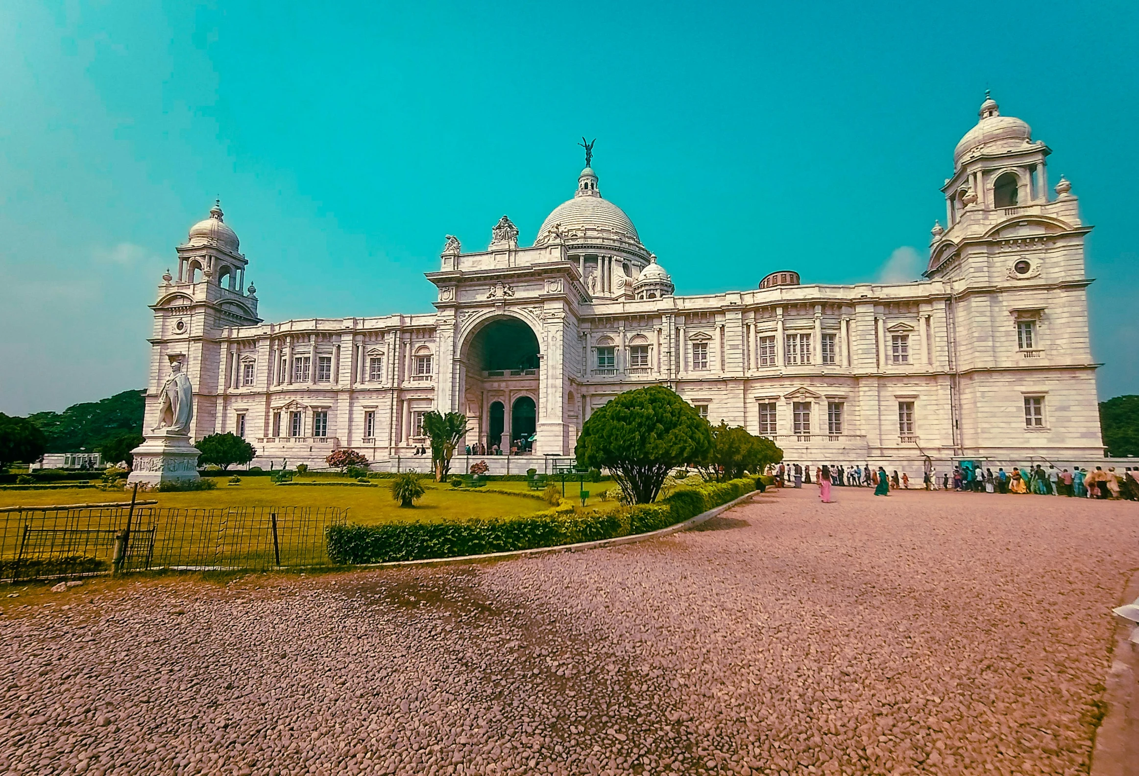 large building with many towers on top sitting in the middle of a field