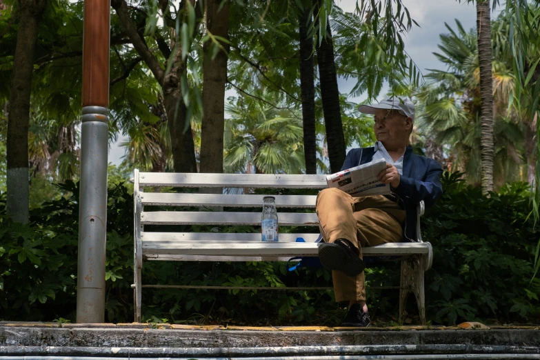 a man in a hat is sitting on a bench