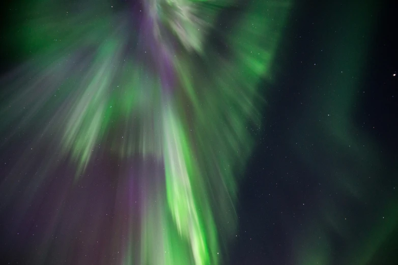 the sky is filled with green and purple aurora lights