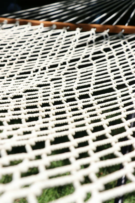 the edge of a hammock that is sitting on a grassy area