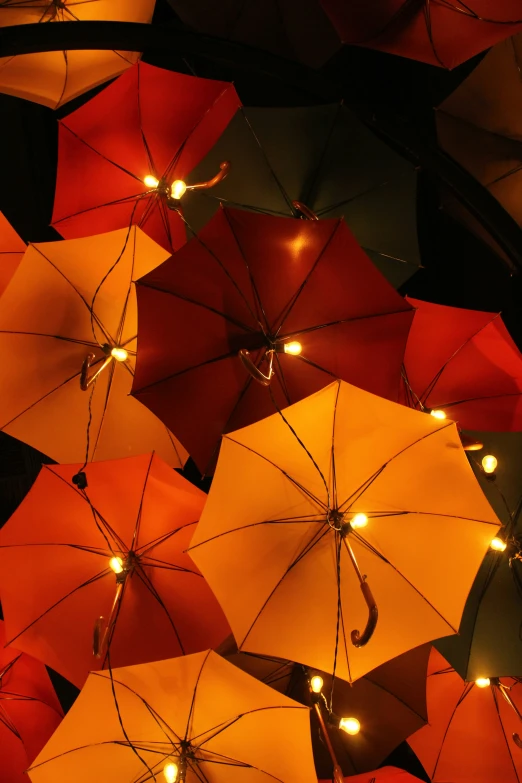 many colorful umbrellas are lit up at night