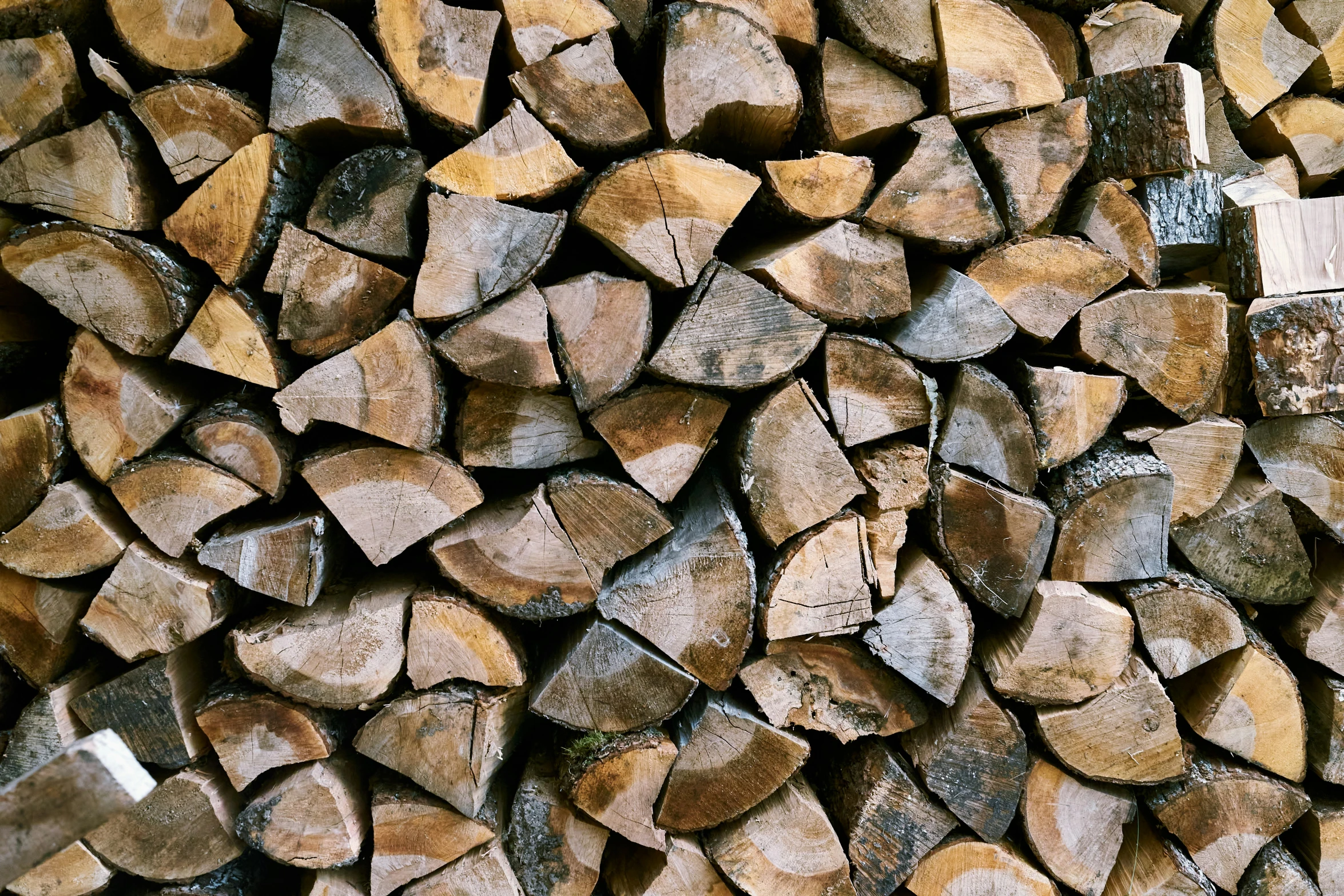 large logs stacked up together on the ground
