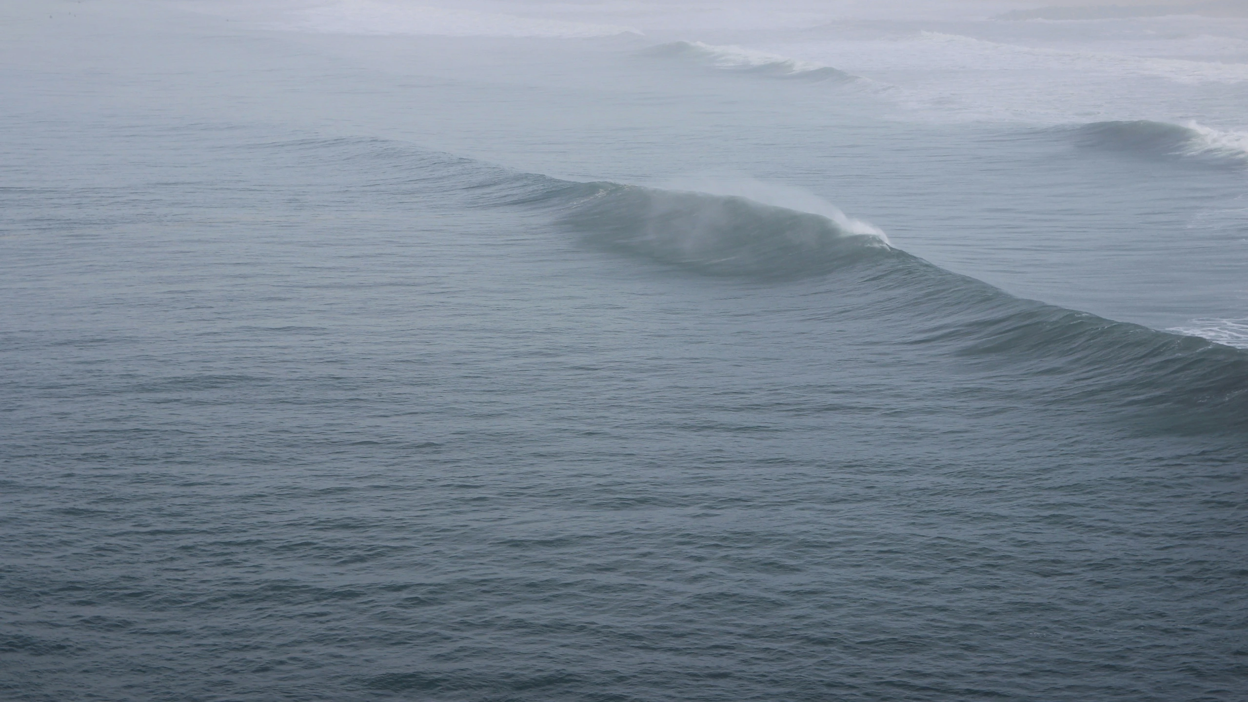 there is a wave in the ocean with small waves